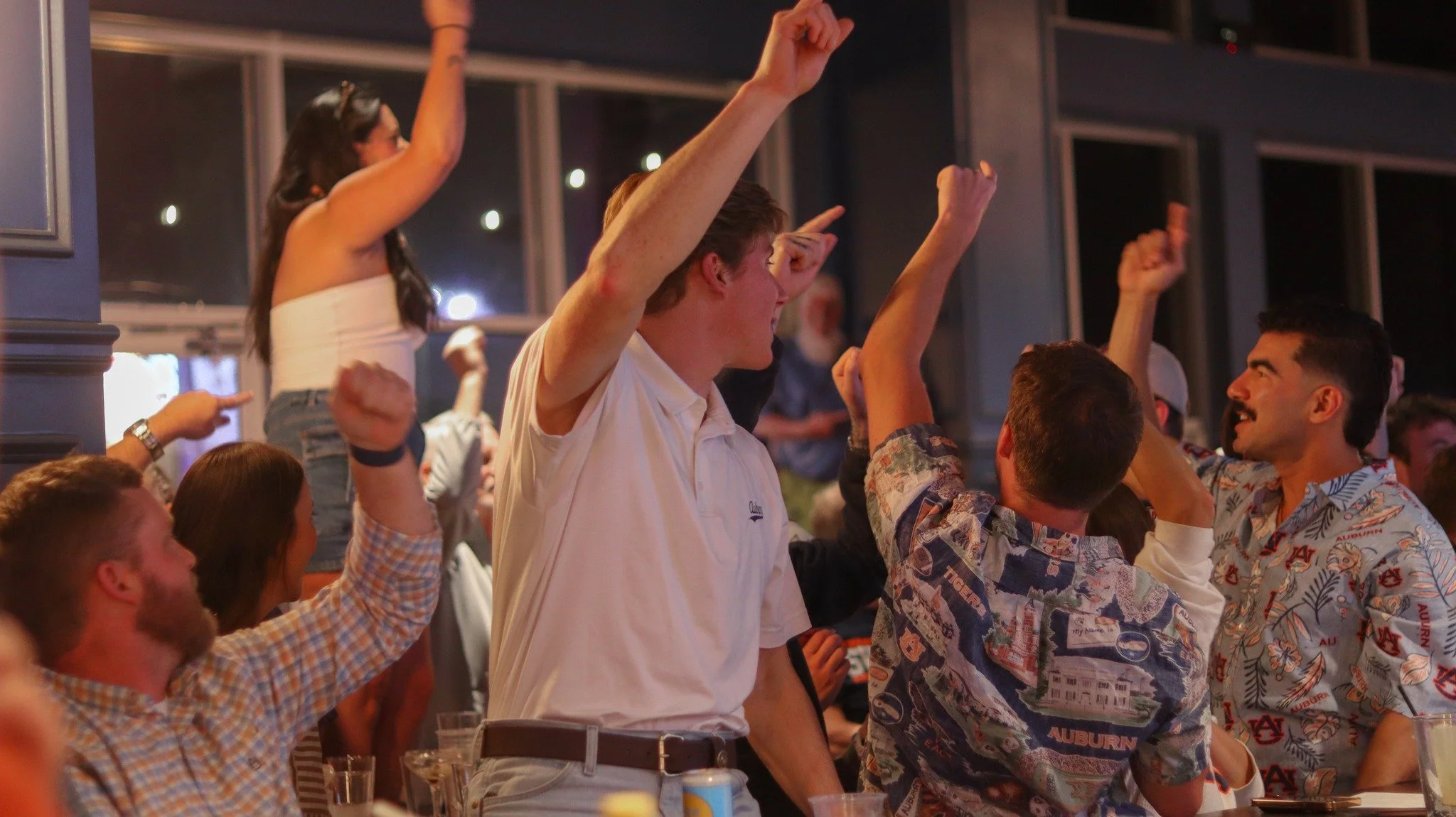The bar at Bunkers on its feet, arms up, mid-cheer