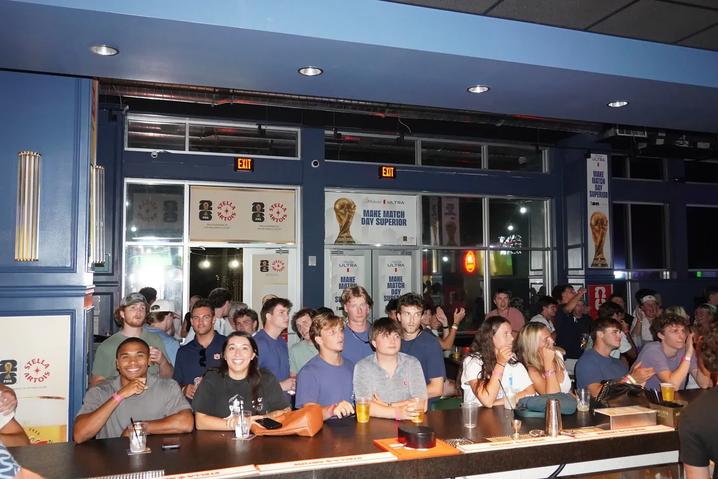 A group along the bar rail at Bunkers with the screens on